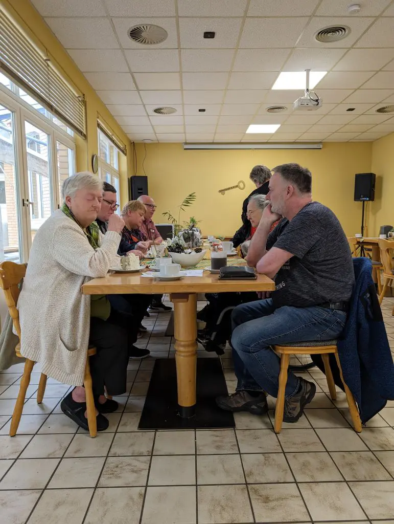 langer Tisch mit sitzenden Besuchern